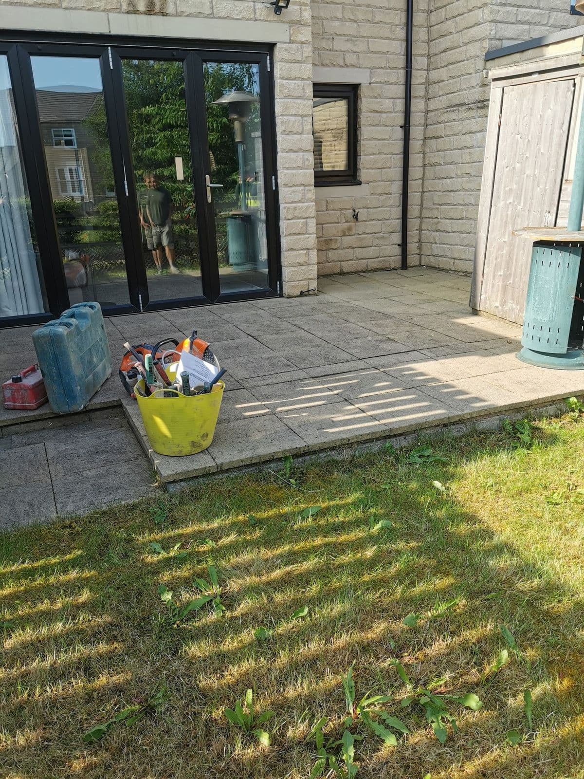 Patchy grass and a narrow strip of old paving outside the back doors before work started