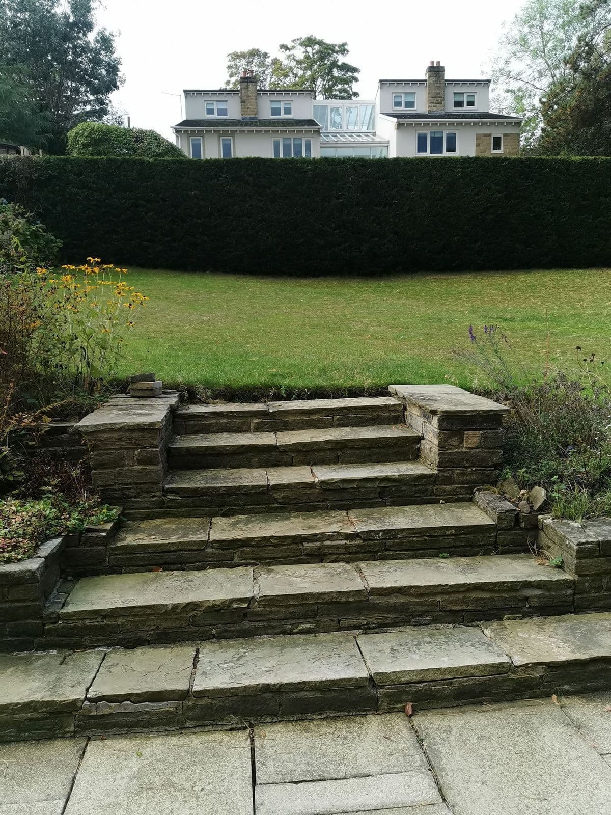 The garden before work: a lawn sloping two metres from the back to the front, with old stone steps