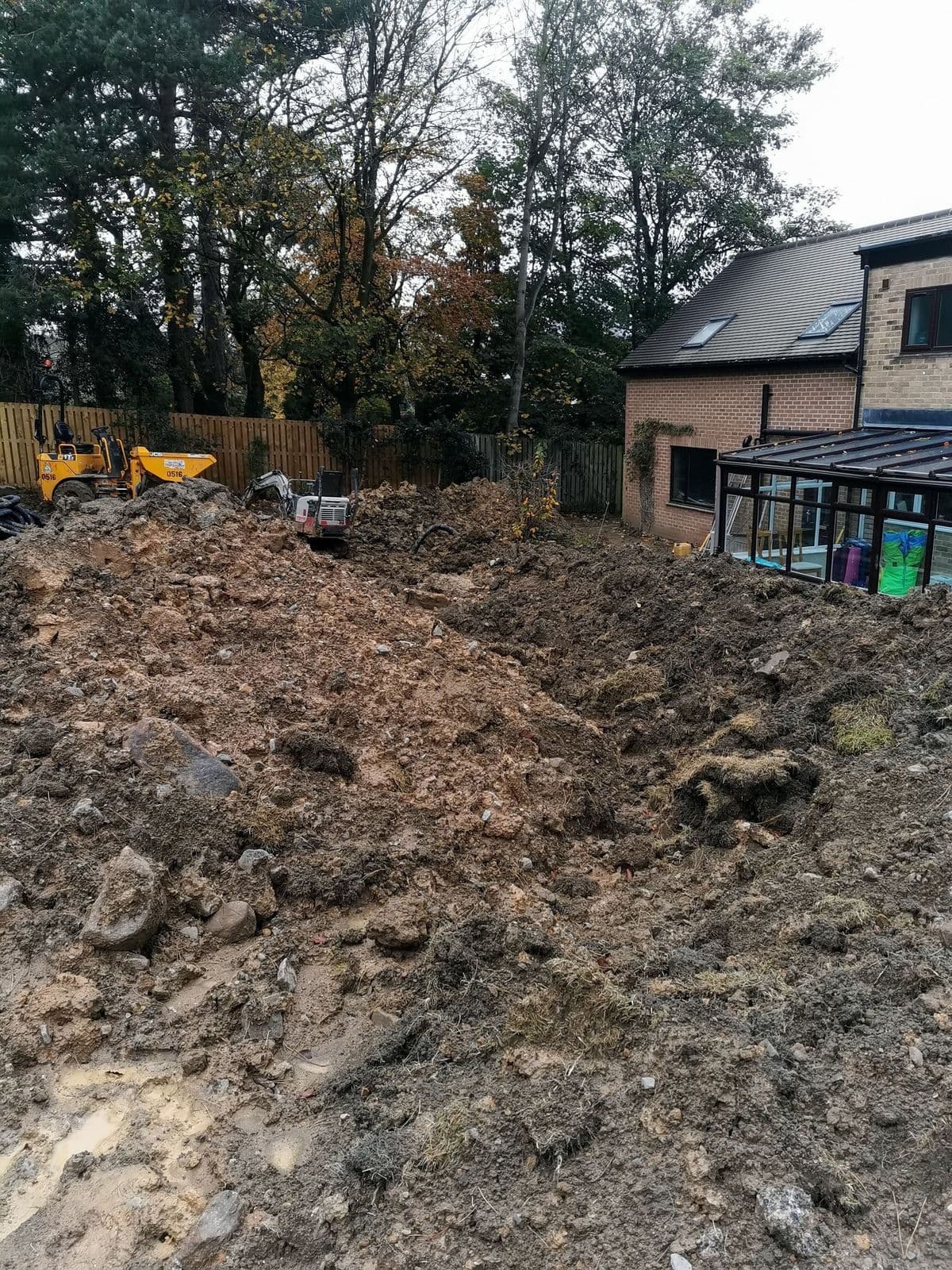 Spoil heaped across the garden with a dumper standing by during the winter build