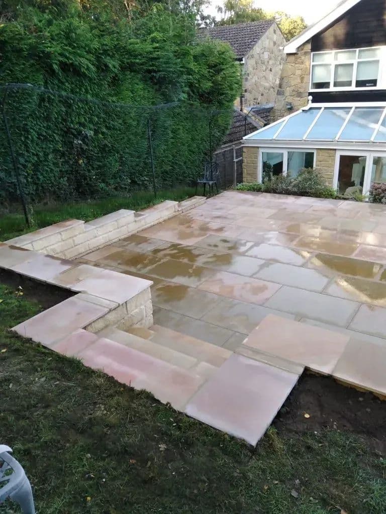 The new patio laid up to a single step, with the house and conservatory behind