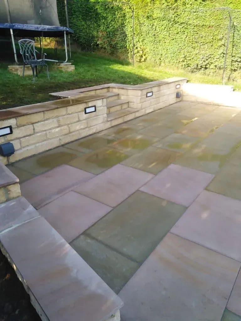 The 900 by 600 Maple pavers running the width of the garden, with lights along the retaining wall