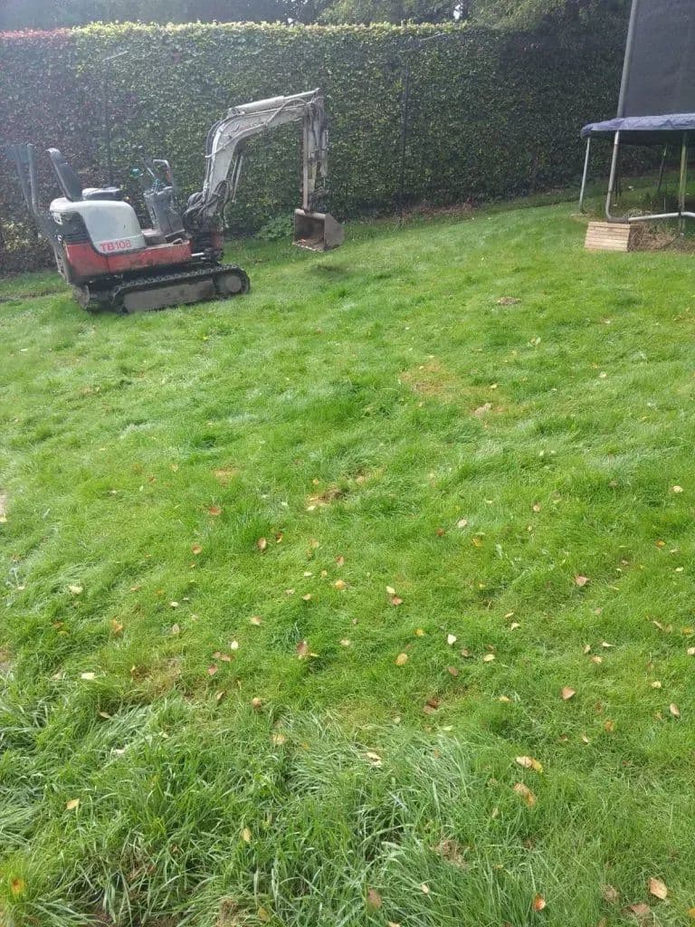 The sloping lawn with a mini digger at the top of it, early in the build