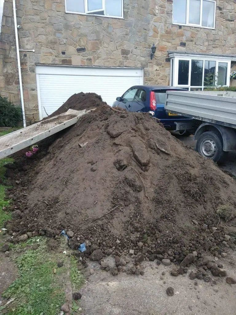 Soil heaped beside the tipper. 37 tons came out of the garden by barrow