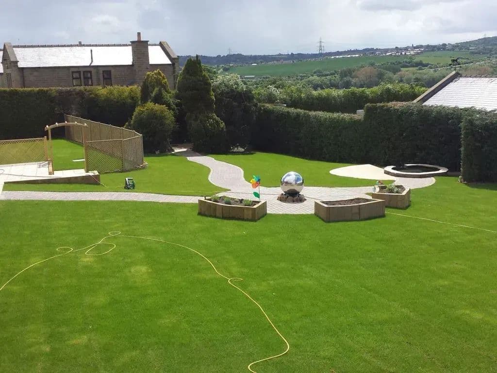 The finished garden from the house: level lawn, curving paths and planted sleeper beds
