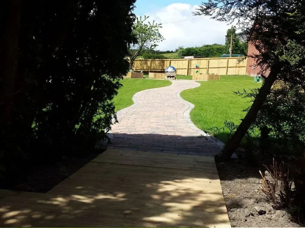The paved path curving away between the trees towards the lawn