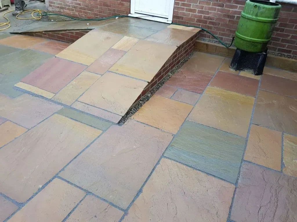The second ramp running up from the paving, laid in the same grippy sandstone flags