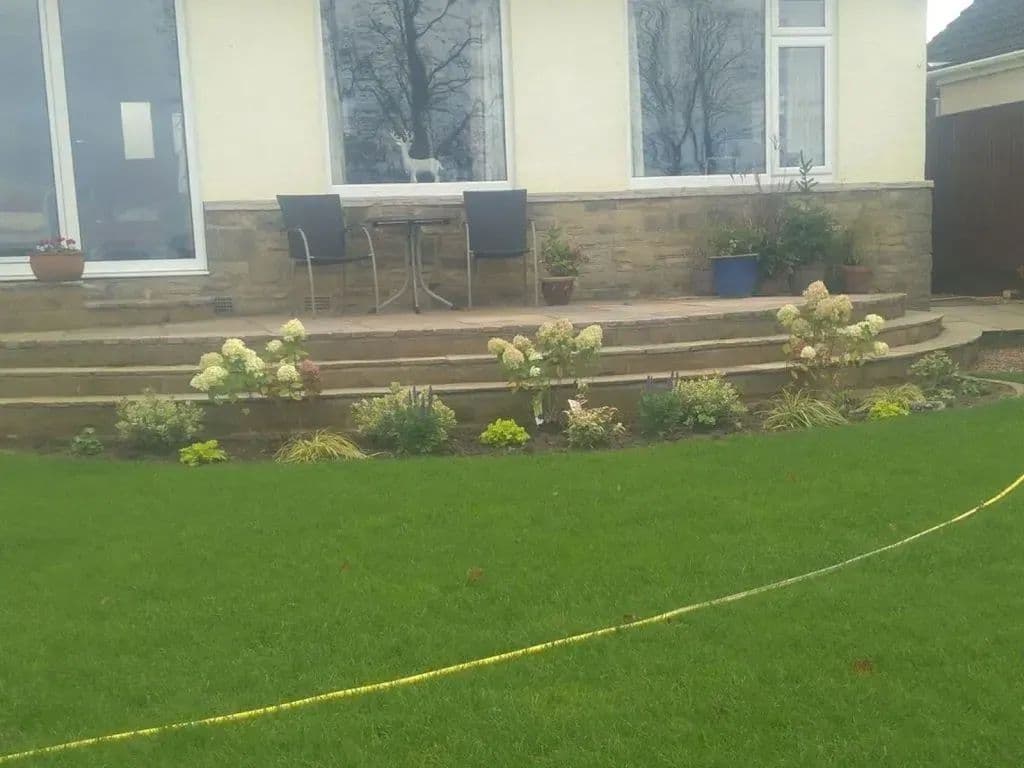 A marking line set out across the lawn during the build, with the steps and planting behind