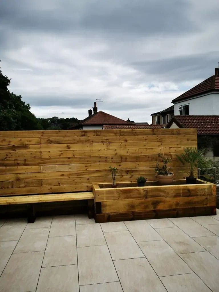The timber bench and planter running along the edge of the porcelain patio
