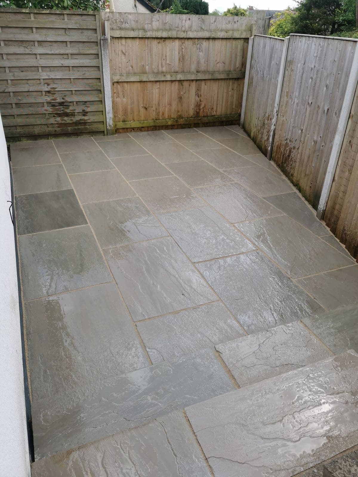 The same space paved in Kandla grey single sized pavers, with a full width step at the far end