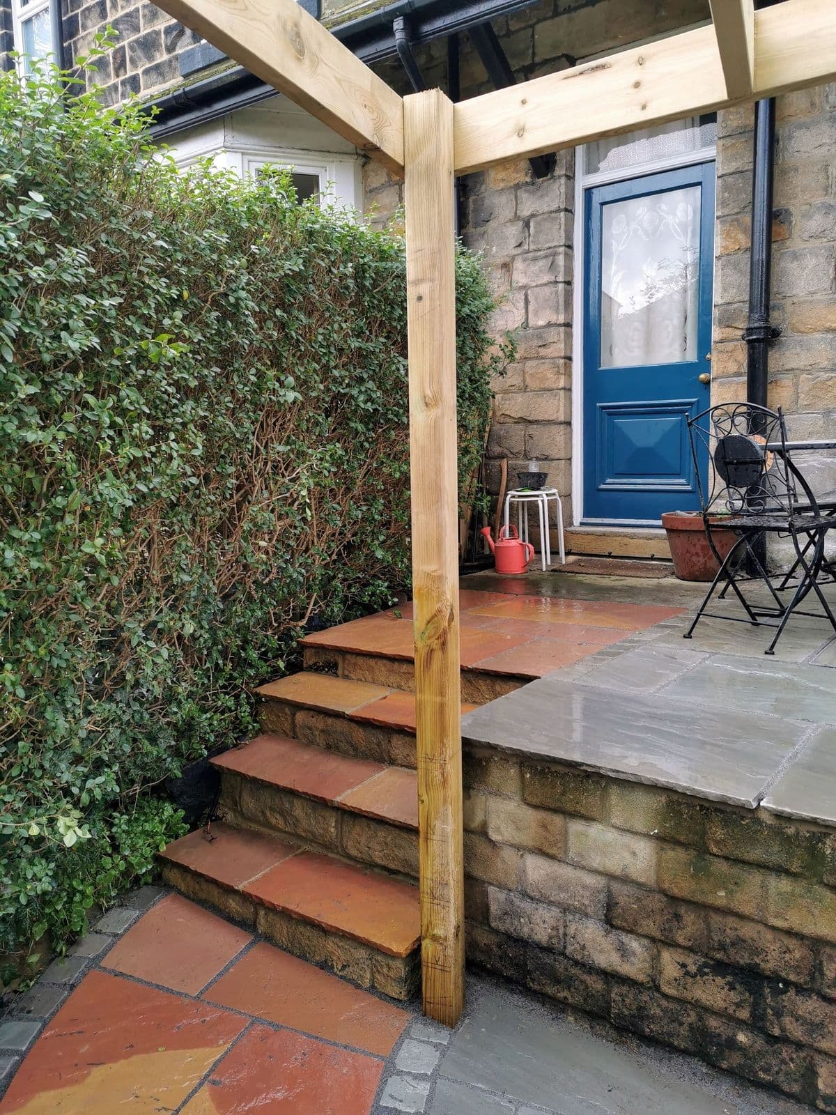 The rebuilt steps in Modak stone leading up to the back door, with a pergola post alongside