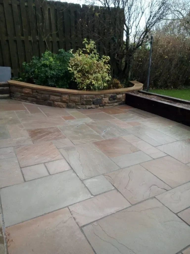 A curved raised bed planted up beside the new paving