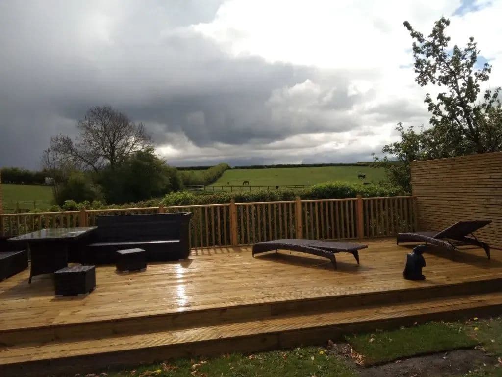 The deck looking out over the fields, with seating and loungers on it