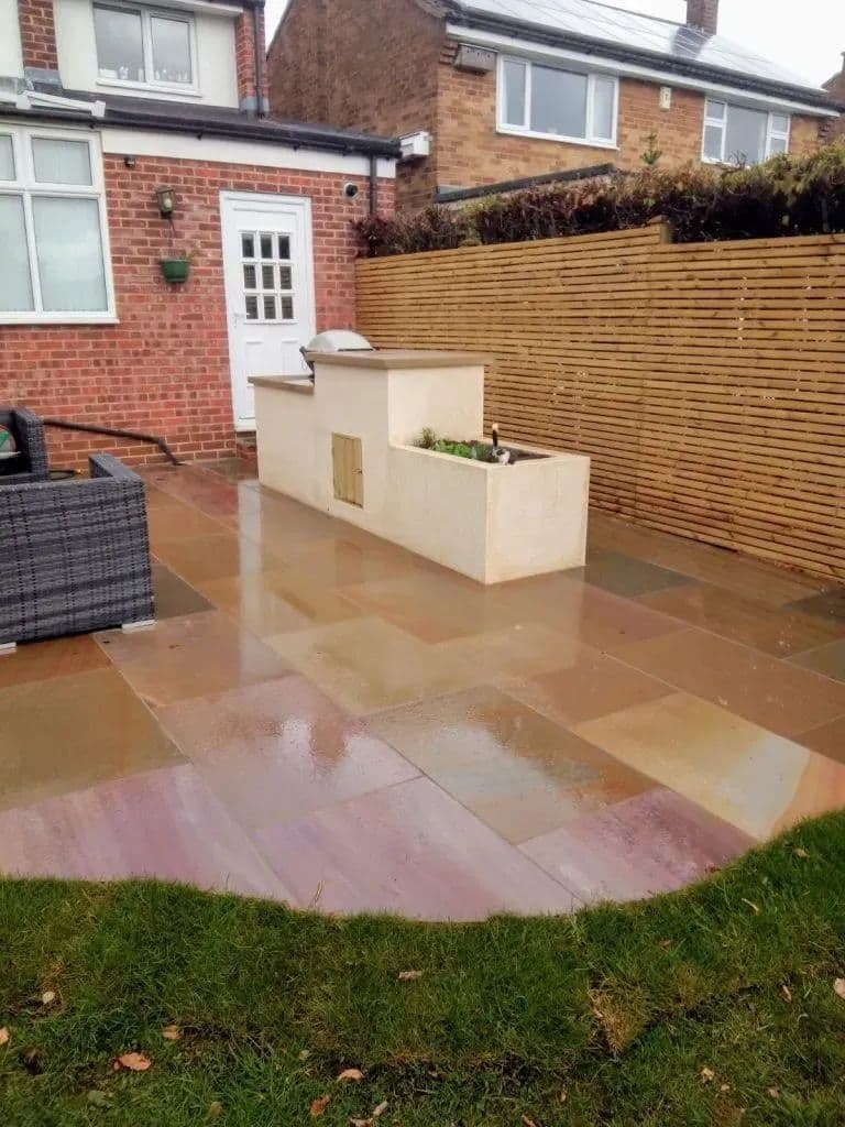 The patio outside the back door with the barbecue and herb planter built into the corner