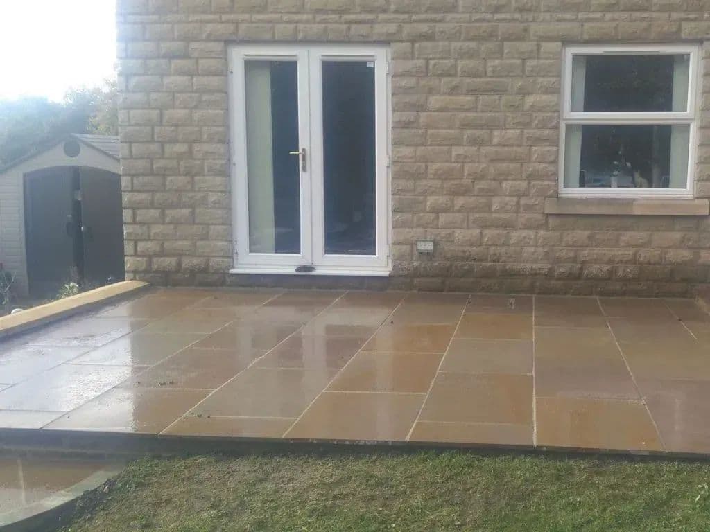 The autumn bronze patio laid outside the French doors, running up to the lawn