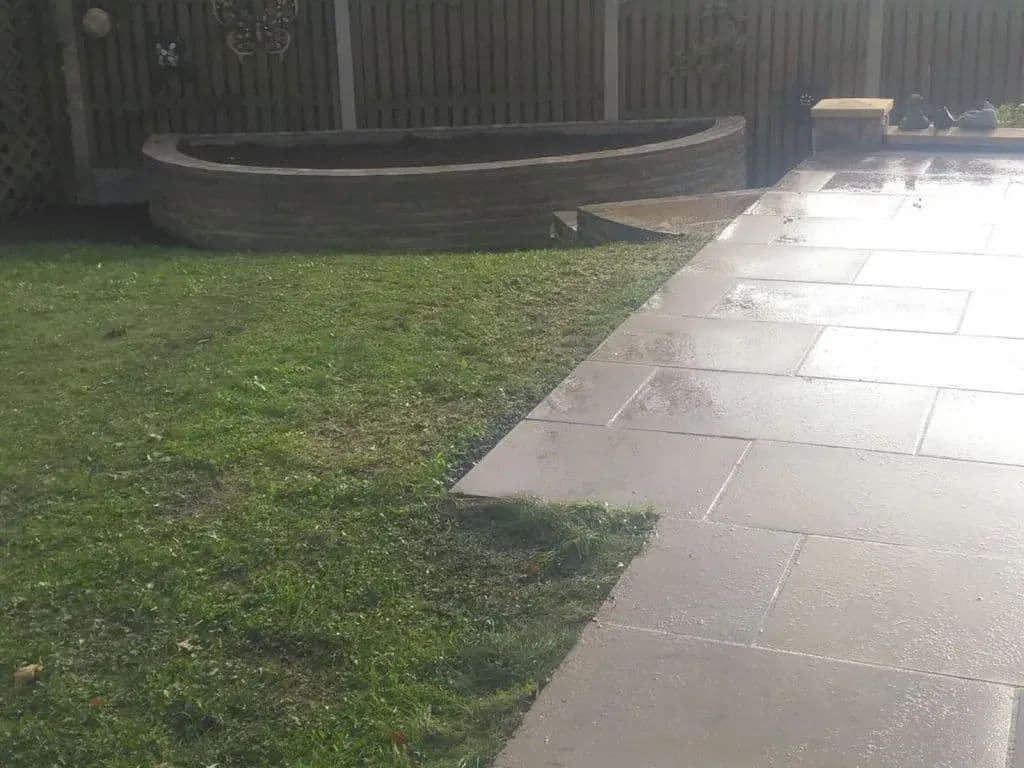 The new paved path running across the lawn towards the semi-circular stone planter