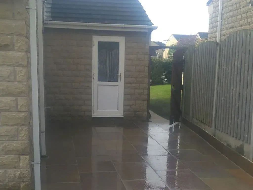 The paved path running past the side door towards the gate