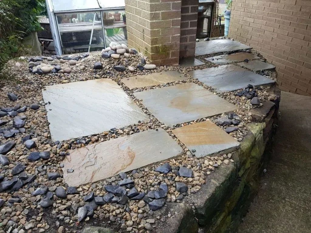 Flags and cobbles laid alongside the greenhouse at the top of the approach