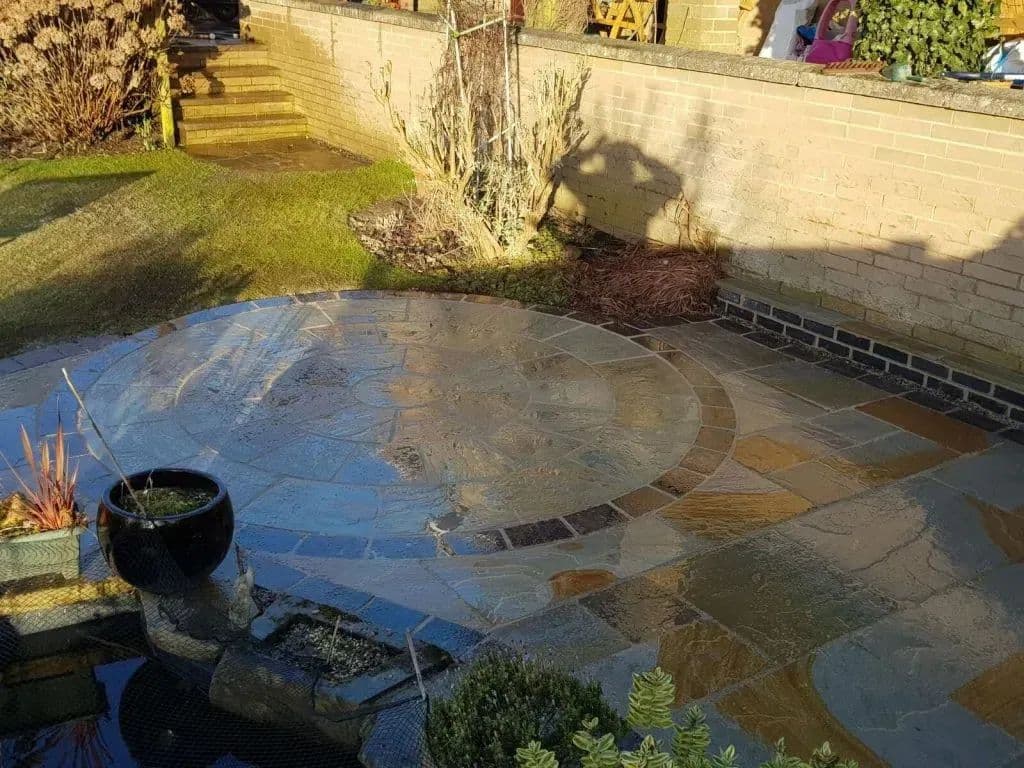The promenade stone circle laid beside the remaining pond, with planting in the corner
