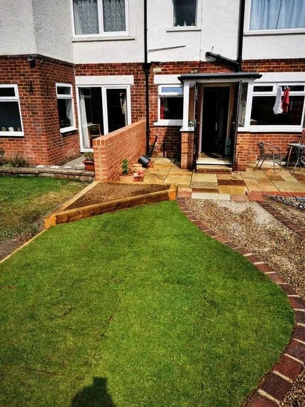 The flattened lawn with brick edging, and the new steps up to the house behind