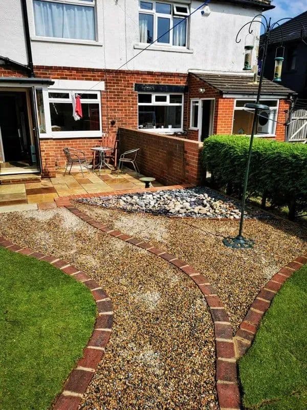 The gravel path, edged in brick, curving through the new lawn