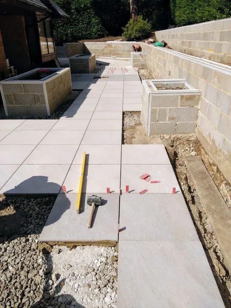 Large porcelain flags being set out on the bedding, with the rendered planters already built