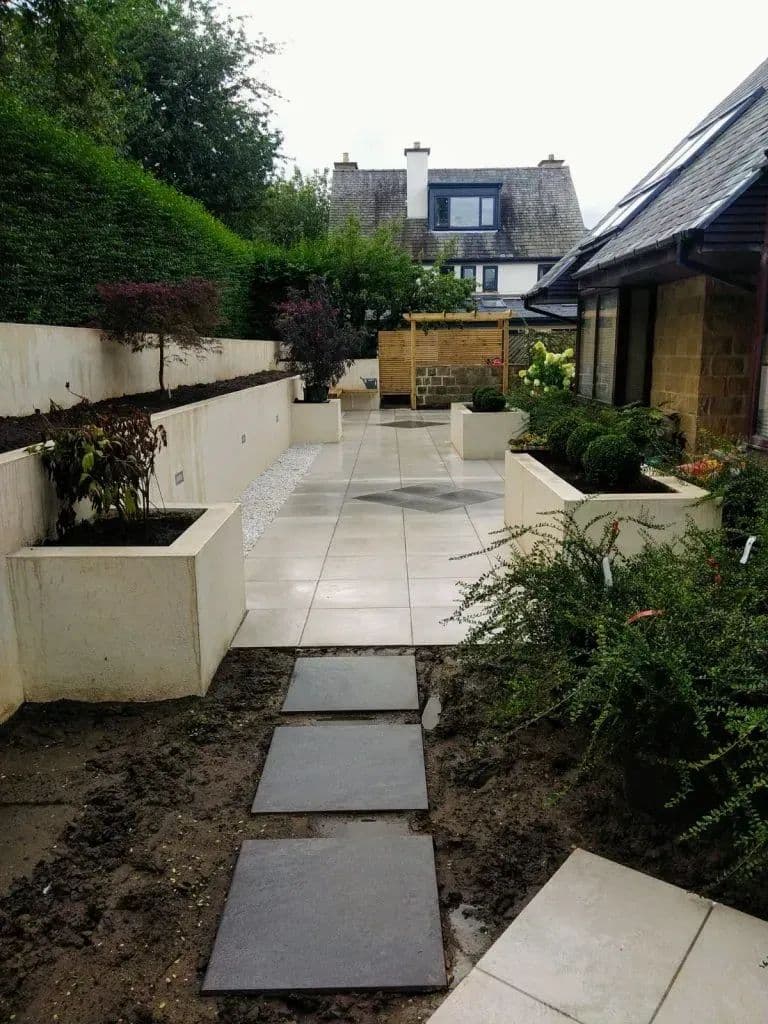 Slate stepping flags set through the beds between the rendered planters