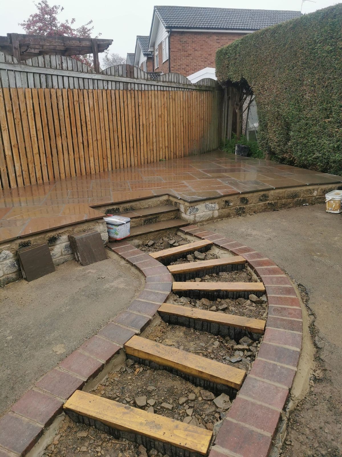 The new steps being built up to the raised patio, with the brick edging set